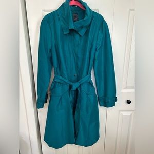 Beautiful turquoise raincoat with two front pockets and bubble hem